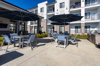 our patio with tables and chairs and umbrellas at our apartments on the strip